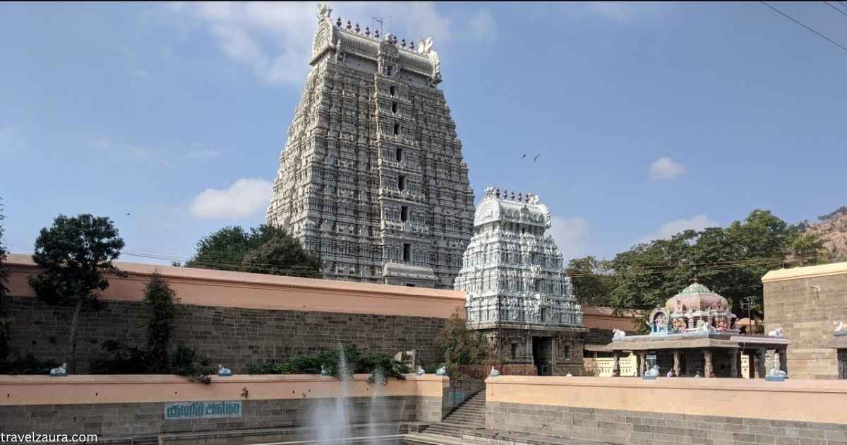 Pilgrims walking Arunachalam Temple Giri Pradakshina around Arunachala Hill at dusk.