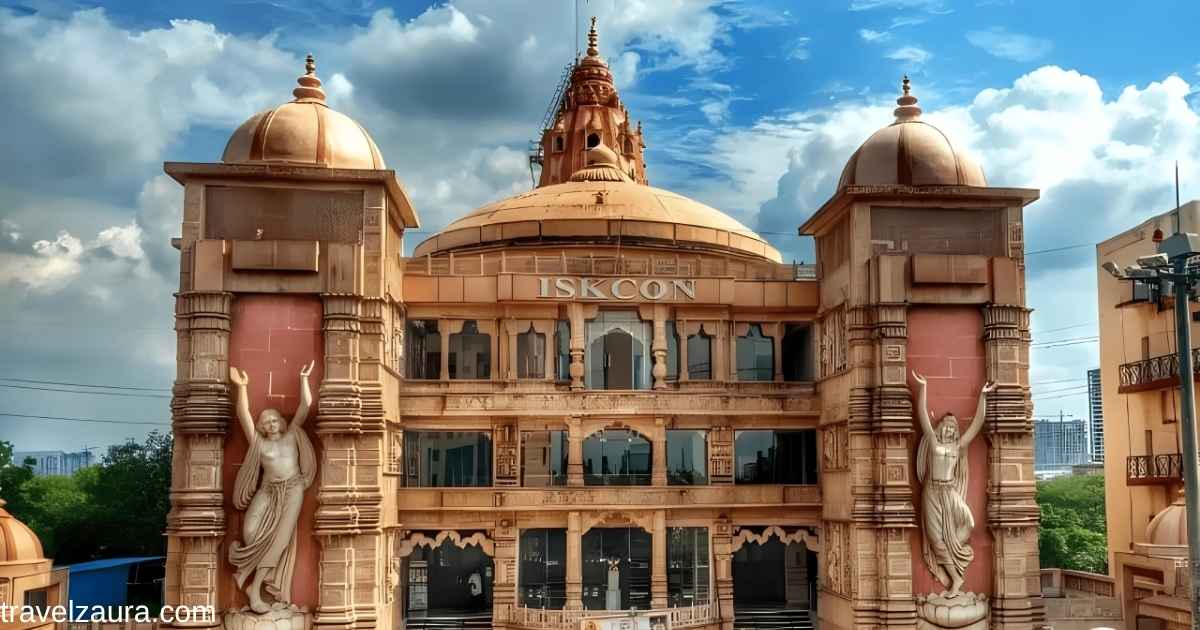 ISKCON Temple Noida's red sandstone facade at sunrise.