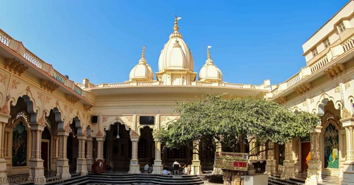 ISKCON Temple Vrindavan exterior view with white domes at sunset.