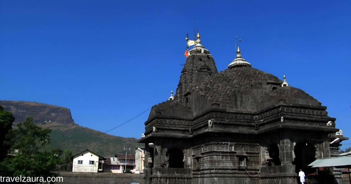 Devotees at Trimbakeshwar temple Nashik's black stone shikhara at sunrise.